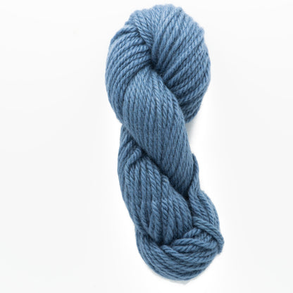 A skein of Halcyon Yarn Classic Rug Wool in a thick, blue hand-dyed hue from Caledonian Dye Works is twisted and displayed against a white background. The yarn appears soft and plush, making it ideal for knitting or crocheting cozy garments or accessories that are beloved by weavers.