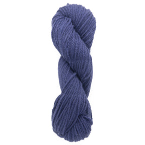 A neatly twisted skein of Halcyon Deco Rug Wool from Caledonian Dye Works, showcasing a deep blue hue with a soft, textured appearance perfect for knitting or crocheting. This versatile yarn is uniformly wound, highlighting its thickness and smooth, consistent fiber.