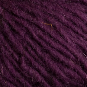 Close-up image of thick, textured yarn in a deep purple color. The strands of Caledonian Dye Works' Halcyon Geo Rug Wool appear soft and slightly fuzzy, with a few visible fibers loose on the surface. The yarn is densely wound, creating a rich and cozy look.