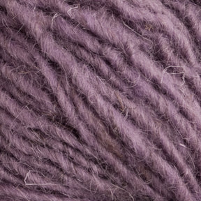 Close-up of a ball of yarn in a soft lavender color, showcasing the texture and fibrous details of the strands. The slightly fuzzy Halcyon Geo Rug Wool from Caledonian Dye Works is suitable for knitting or crocheting.