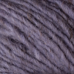 Close-up of gray and purple Halcyon Geo Rug Wool strands from Caledonian Dye Works, showcasing the texture and fibers intertwined. The image highlights the softness and intricate details of the wool, with variations in color and thickness throughout.