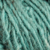 Close-up image of thick, fluffy, teal-colored Halcyon Geo Rug Wool from Caledonian Dye Works with a slightly fuzzy texture. The fibers appear soft and intertwined.