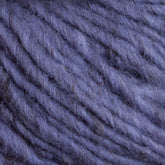 Close-up image of soft, chunky, purple yarn with visible individual strands and fibers entwined together. The texture appears fuzzy and thick, reminiscent of Caledonian Dye Works' Halcyon Geo Rug Wool, making it suitable for knitting or crocheting cozy items.