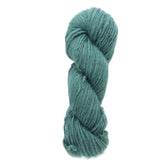 A skein of Caledonian Dye Works' Halcyon Geo Rug Wool in a vibrant teal hue, twisted into a cylinder shape, showcasing its thick and soft texture. The yarn appears fluffy and ideal for knitting or crocheting cozy garments and accessories.