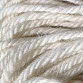 Close-up of a bundle of Halcyon Yarn 4-ply Rug Wool by Lemieux, in a soft, cream color, intricately twisted and overlapping, perfect for latch hooking.