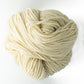 A skein of Lemieux Halcyon Yarn 4-ply Rug Wool, weighing 16 oz and in an off-white hue, is coiled loosely against a plain white background. The thick, soft yarn appears chunky and is ideal for rug hookers as well as suitable for knitting or crocheting.