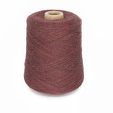 The Jagger Brothers, Inc.'s JaggerSpun Heather 2/20 is a large spool of multicolored, top-dyed worsted spun wool yarn featuring shades of maroon, brown, and hints of purple. This heather effect yarn is wound tightly around a cardboard core and stands upright against a plain white background.