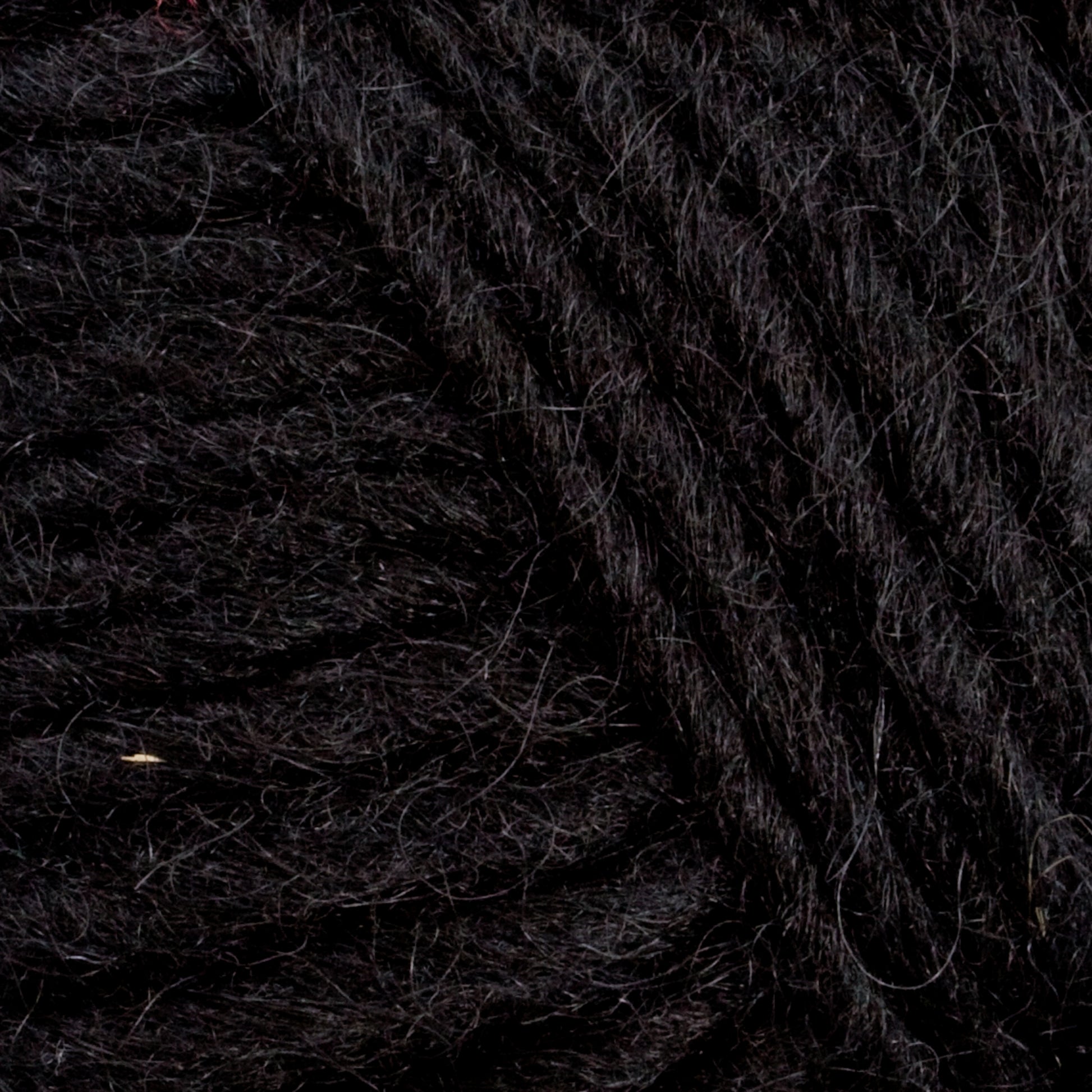 Close-up view of dark black Lopi Alafoss Icelandic Wool Yarn by Berroco, Inc., showing the intricate and textured fibers intertwined together. The yarn appears dense and thick, suitable for knitting cozy Icelandic pullovers or crocheting durable felted mittens.