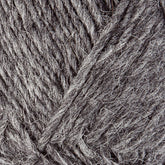 Close-up of grey Lopi Alafoss Icelandic Wool Yarn by Berroco, Inc., showcasing its coarse texture and intertwined fibers. The yarn appears thick and made of natural material, ideal for knitting or crocheting projects like felted mittens or Icelandic pullovers. The color offers varying shades of grey, adding depth to the texture.