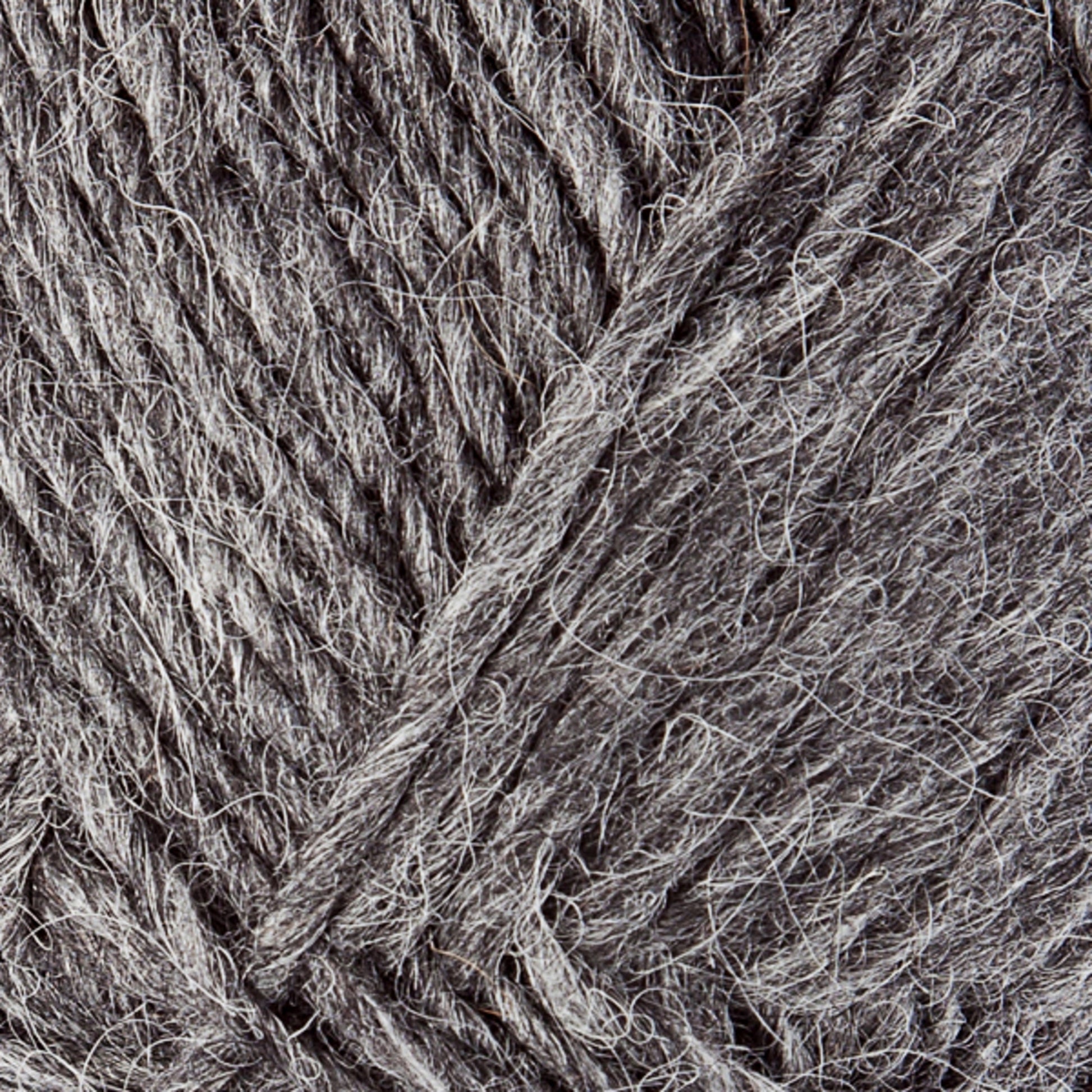 Close-up of grey Lopi Alafoss Icelandic Wool Yarn by Berroco, Inc., showcasing its coarse texture and intertwined fibers. The yarn appears thick and made of natural material, ideal for knitting or crocheting projects like felted mittens or Icelandic pullovers. The color offers varying shades of grey, adding depth to the texture.