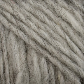 Close-up image showing a bundle of thick, gray Lopi Alafoss Icelandic Wool Yarn by Berroco, Inc. with a textured, fibrous appearance. The strands intertwine, showcasing the natural variances in shade and the presence of darker threads intertwined with the lighter wool. This exquisite material is perfect for Icelandic pullovers.