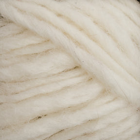 Close-up of thick, soft, white Lopi Alafoss Icelandic Wool Yarn by Berroco, Inc. intertwined loosely. The fibers appear fluffy and slightly fuzzy, showcasing the yarn's texture and natural color—perfect for crafting Icelandic pullovers.