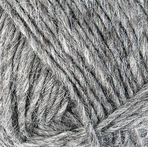 Close-up of Lopi Alafoss Icelandic Wool Yarn by Berroco, Inc., tightly spun and textured with a natural, fibrous appearance. The grey strands are intertwined, showing subtle variations in shade and thickness. Ideal for crafting felted mittens or Icelandic pullovers, it exudes the warmth and softness typical of knitting materials.