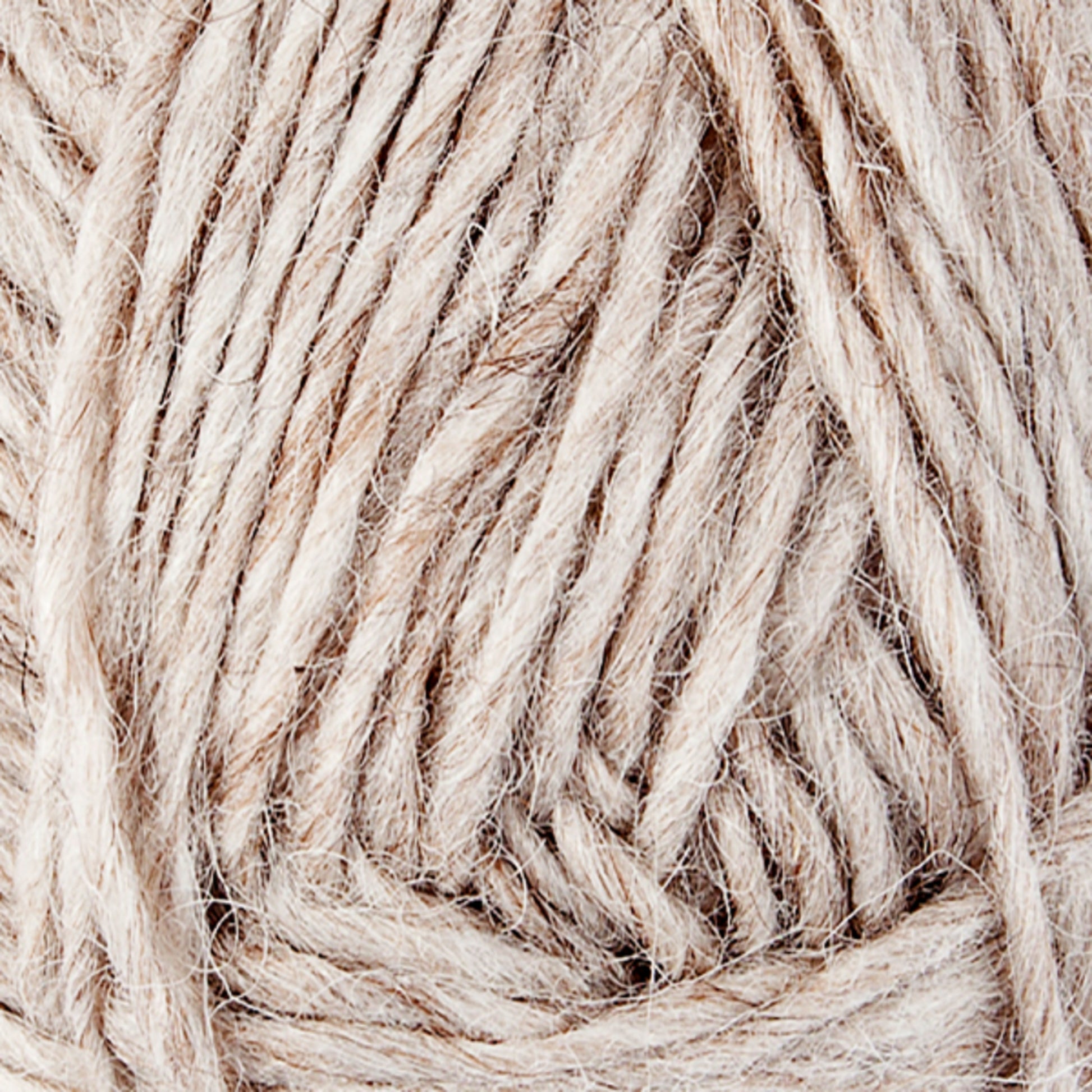 Close-up image of a ball of beige, natural-colored Lopi Alafoss Icelandic Wool Yarn by Berroco, Inc., showing its fibrous texture and tightly wound strands. The yarn appears soft and slightly fuzzy, perfect for knitting or crocheting projects like Icelandic pullovers.