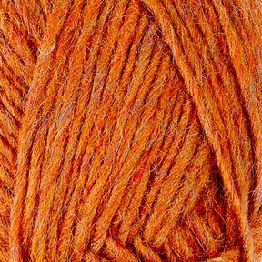 A close-up view of orange yarn, displaying the texture and fibers of the wool. The strands are tightly wound together, highlighting the detailed, fuzzy surface of this Lopi Alafoss Icelandic Wool Yarn by Berroco, Inc., often used in Icelandic pullovers.