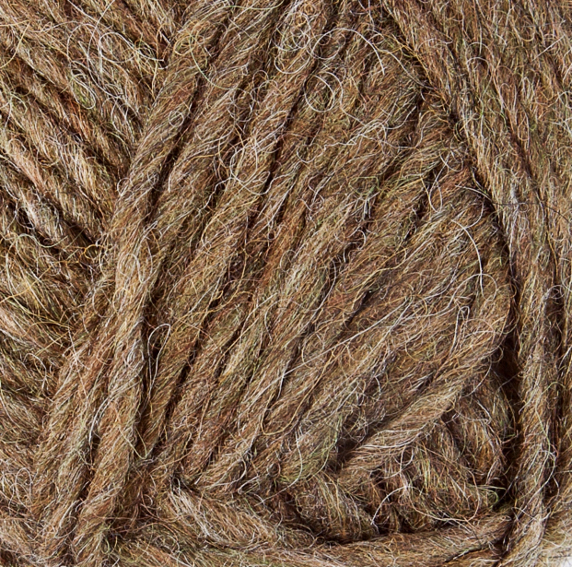 A close-up image of a ball of Lopi Alafoss Icelandic Wool Yarn from Berroco, Inc., showing strands of intertwined fibers. The yarn is composed of shades of brown, beige, and touches of grey, giving it a natural, earthy appearance. The fibers appear soft and slightly fuzzy.