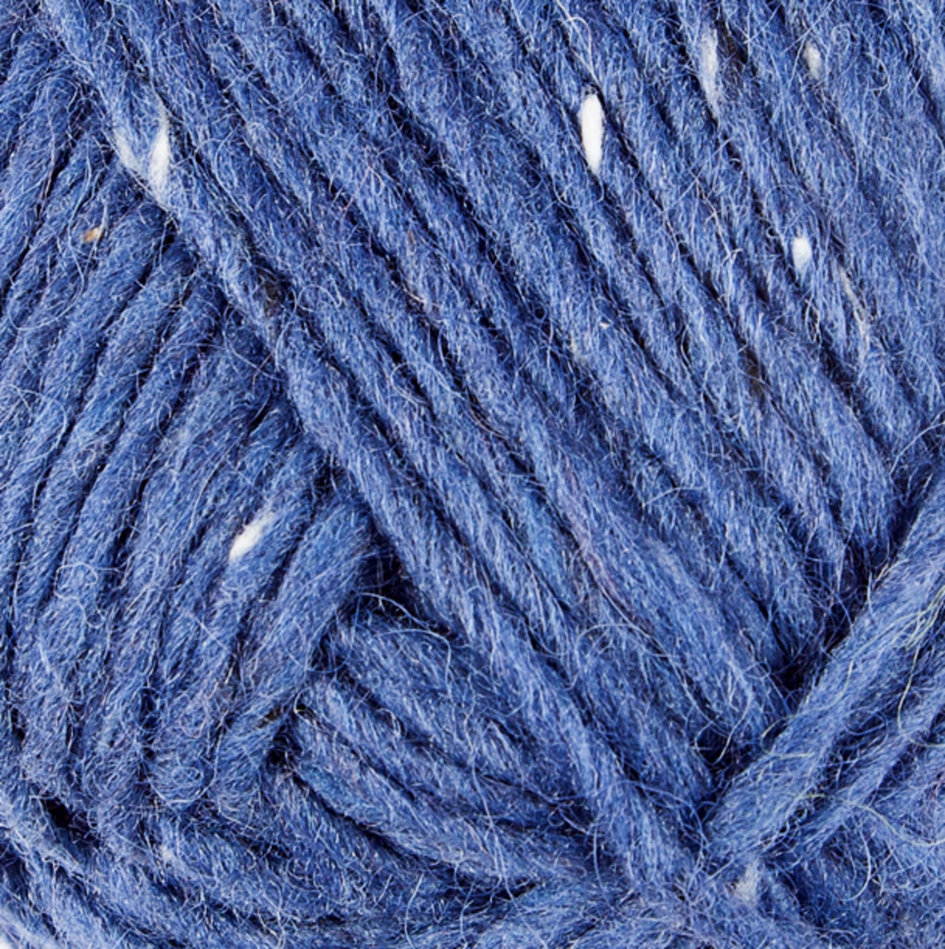 A close-up shot of a ball of Lopi Alafoss Icelandic Wool Yarn by Berroco, Inc. in a striking blue shade with delicate white flecks woven throughout. The yarn's soft texture and clearly visible individual strands showcase the intricate twists of the fibers. The image highlights the yarn's detailed and complex texture, ideal for crafting traditional Icelandic pullovers.