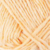 Close-up image of a ball of soft, light orange Lopi Alafoss Icelandic Wool Yarn by Berroco, Inc., with visible strands and fibers, showcasing its texture. The yarn is tightly wound and has a slightly fuzzy appearance, perfect for crafting Icelandic pullovers or felted mittens.