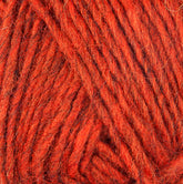 Close-up of the Lopi Alafoss Icelandic Wool Yarn by Berroco, Inc., highlighting its texture. The yarn appears thick and slightly fuzzy, with strands twisted together. Its vibrant, warm orange hue features subtle tonal variations, making it perfect for crafting cozy Icelandic pullovers or felted mittens.