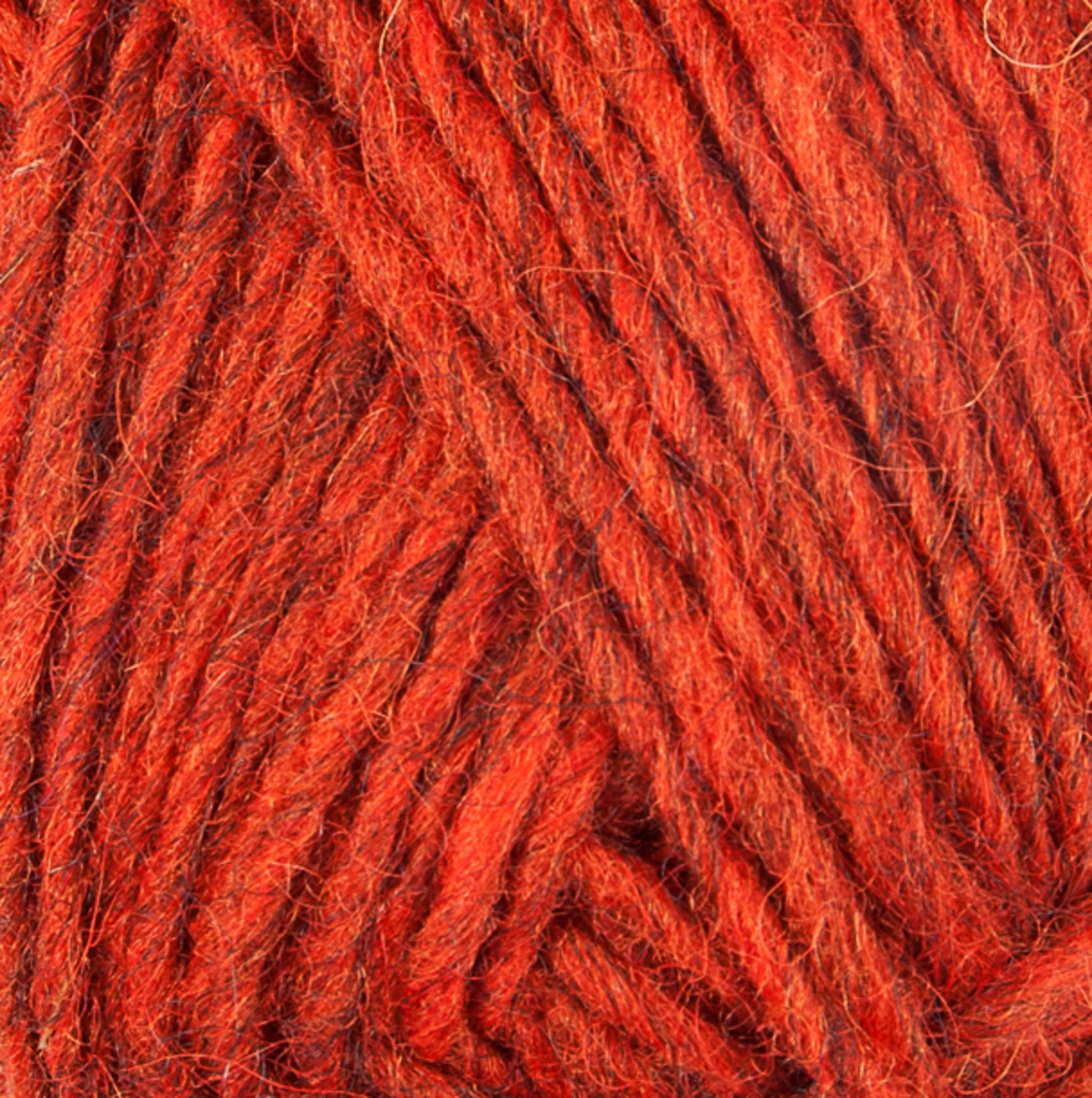 Close-up of the Lopi Alafoss Icelandic Wool Yarn by Berroco, Inc., highlighting its texture. The yarn appears thick and slightly fuzzy, with strands twisted together. Its vibrant, warm orange hue features subtle tonal variations, making it perfect for crafting cozy Icelandic pullovers or felted mittens.