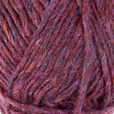 Close-up image of Lopi Alafoss Icelandic Wool Yarn by Berroco, Inc. showcasing intertwined purple strands with subtle multicolored fibers, including hints of blue and pink, giving the yarn a rich, textured appearance perfect for crafting Icelandic pullovers.