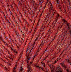 Close-up image of Lopi Alafoss Icelandic Wool Yarn by Berroco, Inc. in red with subtle interwoven blue and gold fibers creating a textured appearance. The thick, slightly fuzzy strands are reminiscent of the yarn used in Icelandic pullovers, with loose ends visible in some areas. The yarn appears to be bundled together in a tidy manner.