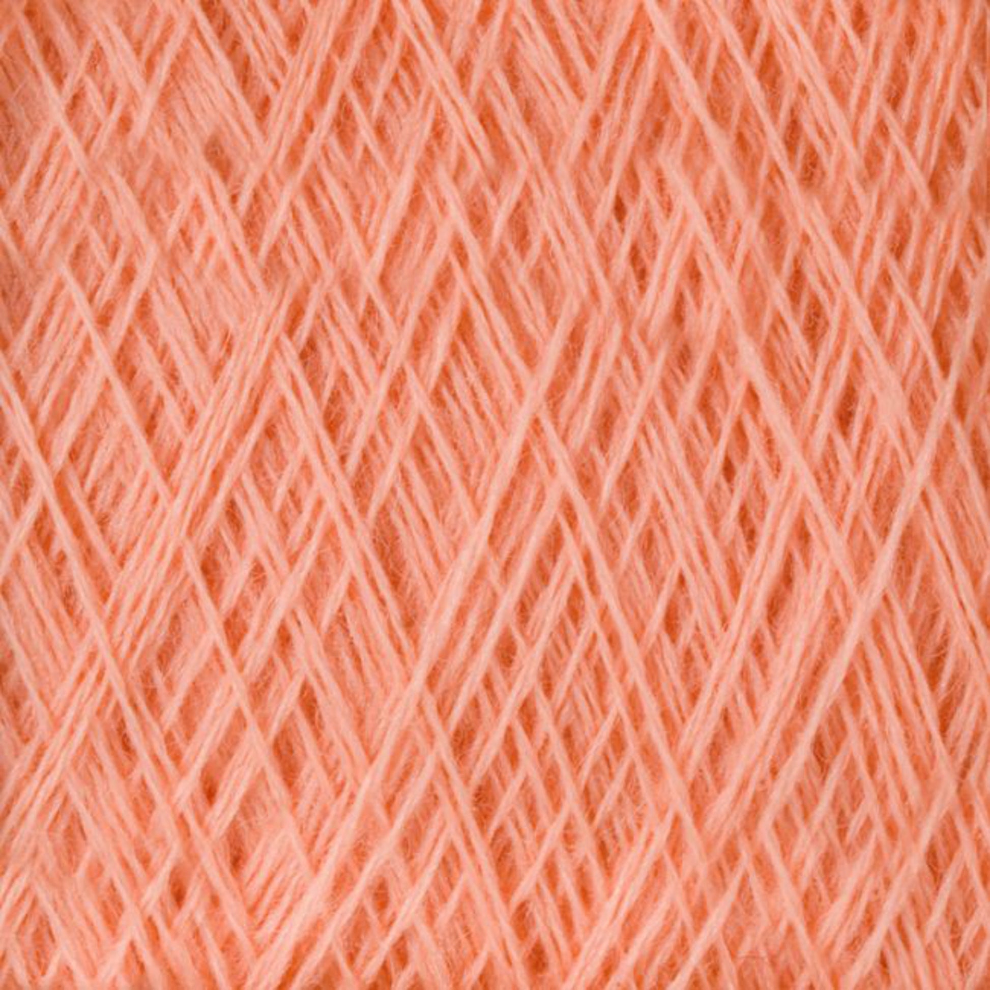 A close-up view of the JaggerSpun Maine Line 3/8 Yarn | Mini-cone fibers intersecting in a crisscross pattern, creating a textured surface. The Jagger Brothers, Inc. yarns are neatly arranged, showcasing the fine and soft threads that make up the material. The color is a warm, light shade of orange.