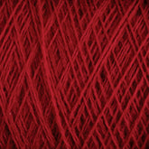 Close-up view of a ball of JaggerSpun Maine Line 2/8 Yarn | Mini-cone by Jagger Brothers, Inc., showcasing the intricate interwoven strands and the soft, fuzzy texture typical of worsted spun yarn. The crisscross pattern highlights the thickness and richness of the red color, reminiscent of fine knitting or weaving.