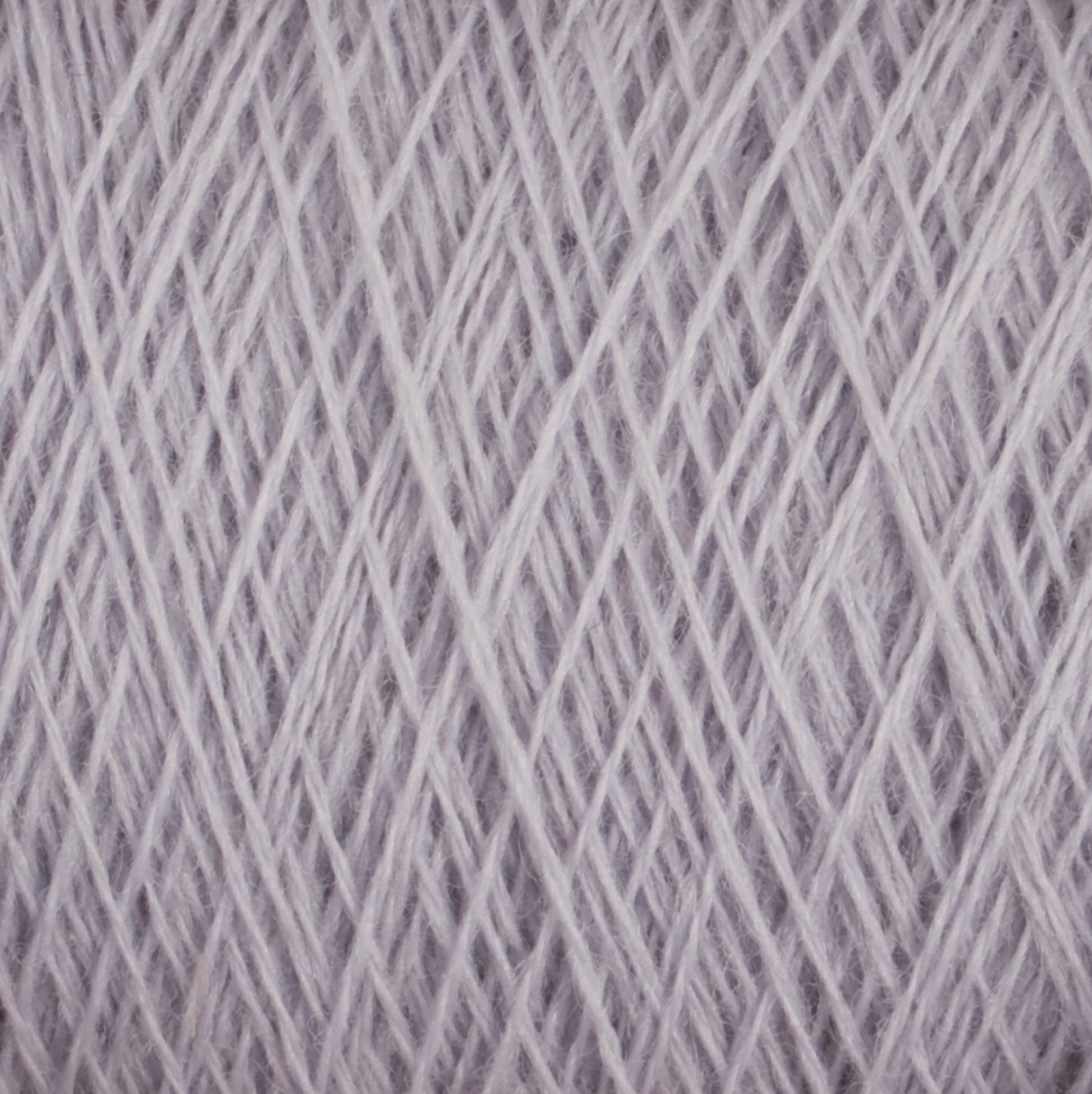 A close-up view of Jagger Brothers, Inc.'s JaggerSpun Maine Line 2/8 Yarn | Large Cone in a lavender hue reveals its 27.5 micron worsted spun wool fibers wound tightly in a crisscross pattern. The thin fibers exhibit a soft and delicate texture, making it perfect for both commercial and recreational knitters working on knitting or crocheting projects.