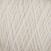 Close-up image of a soft, cream-colored JaggerSpun Maine Line 2/8 Yarn | Mini-cone by Jagger Brothers, Inc. The yarn is tightly wound and reveals intricate patterns of interwoven fibers. The texture appears delicate and fluffy, hinting at a cozy and warm fabric when knitting or crocheting with this worsted spun yarn.