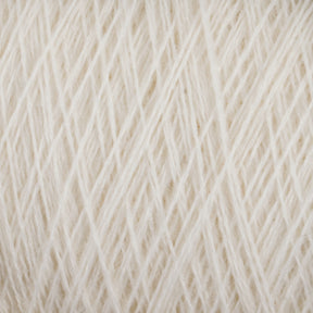 Close-up image of a soft, cream-colored JaggerSpun Maine Line 2/8 Yarn | Mini-cone by Jagger Brothers, Inc. The yarn is tightly wound and reveals intricate patterns of interwoven fibers. The texture appears delicate and fluffy, hinting at a cozy and warm fabric when knitting or crocheting with this worsted spun yarn.