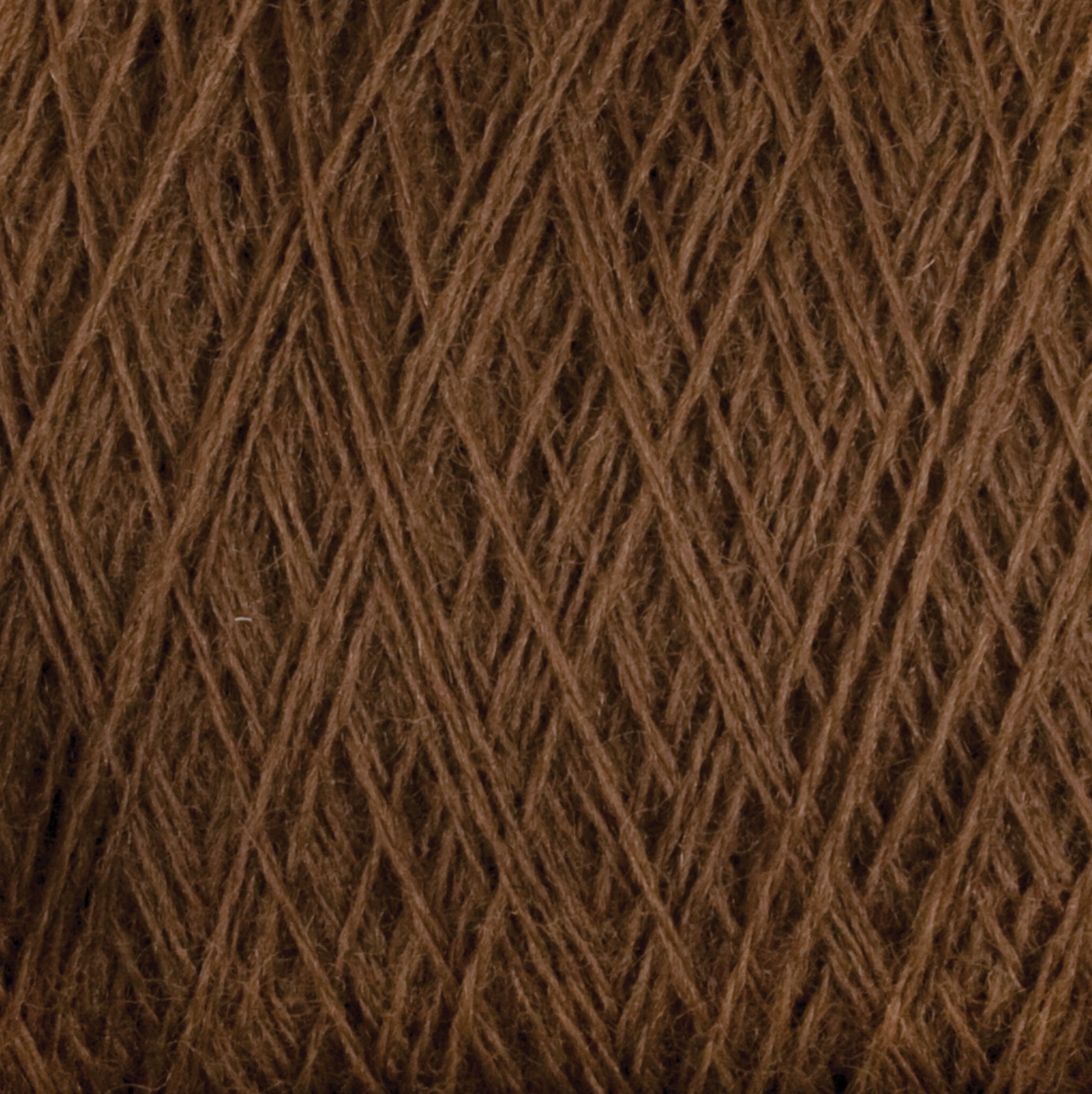 Close-up of JaggerSpun Maine Line 2/8 Yarn | Mini-cone by Jagger Brothers, Inc., tightly wound in a crisscross pattern, showcasing its texture and intricate arrangement. The brown worsted spun fibers appear soft and uniform, creating a rich, earthy tone throughout the image, perfect for knitting or weaving projects.