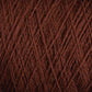 Close-up view of JaggerSpun Maine Line 2/8 Yarn in brown from Jagger Brothers, Inc., showcasing the intricate interwoven fibers and textures. The strands overlap in a detailed pattern, highlighting the natural and rich color of this worsted spun yarn, perfect for weaving or knitting projects.