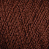 Close-up view of JaggerSpun Maine Line 2/8 Yarn in brown from Jagger Brothers, Inc., showcasing the intricate interwoven fibers and textures. The strands overlap in a detailed pattern, highlighting the natural and rich color of this worsted spun yarn, perfect for weaving or knitting projects.