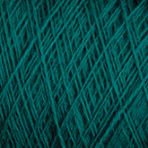 Close-up image of JaggerSpun Maine Line 2/8 Yarn in teal, arranged in a crisscross pattern. The texture appears soft and slightly fluffy, characteristic of worsted spun yarn by Jagger Brothers, Inc., with a rich, deep color that adds a sense of warmth and coziness perfect for knitting projects.