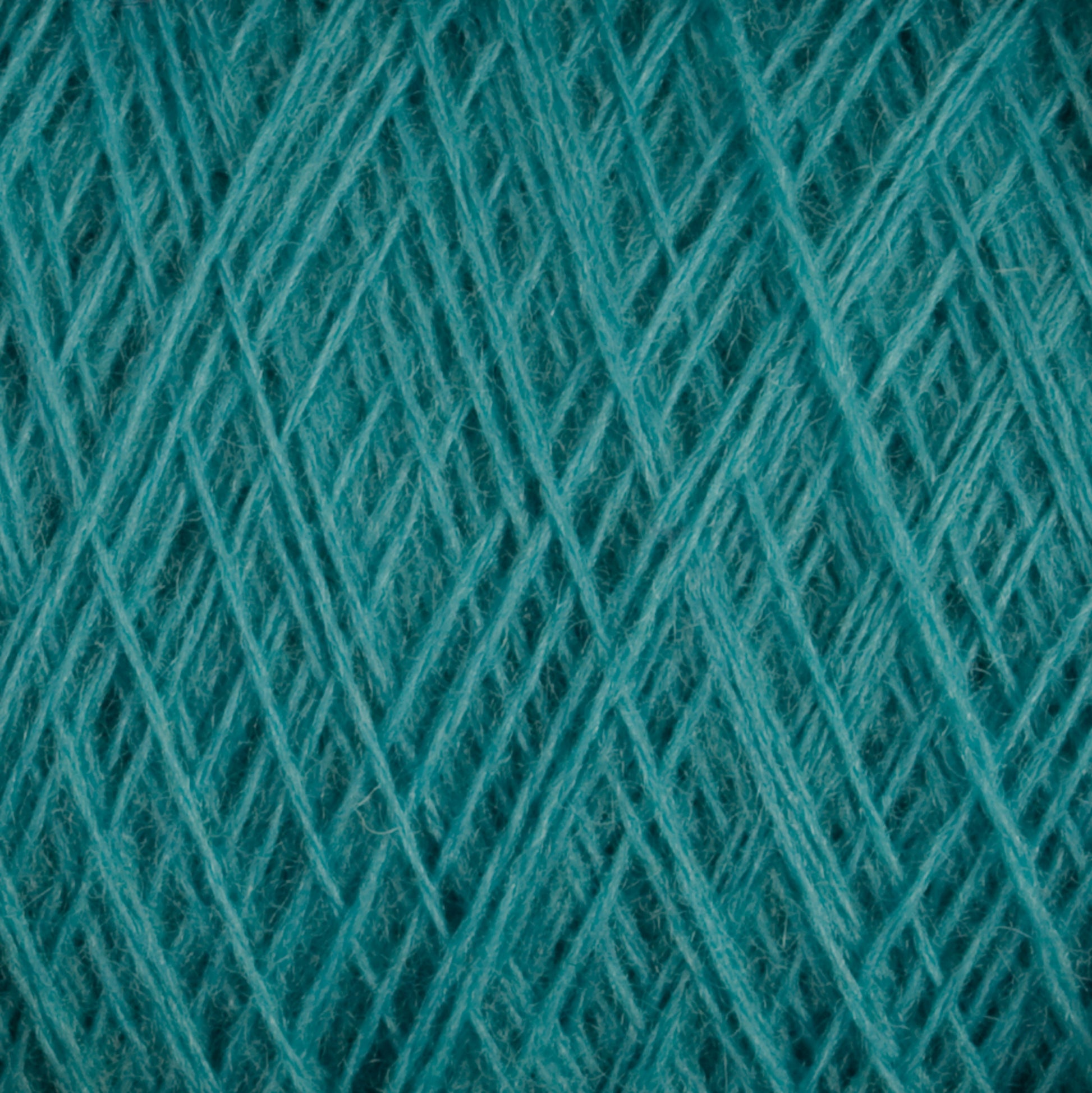 Close-up image of a teal-colored JaggerSpun Maine Line 2/8 Yarn | Mini-cone by Jagger Brothers, Inc. shows detailed fibers interwoven in a crisscross pattern, creating a textured and intricate design. Perfect for knitting or weaving projects, this yarn appears soft and slightly fuzzy.