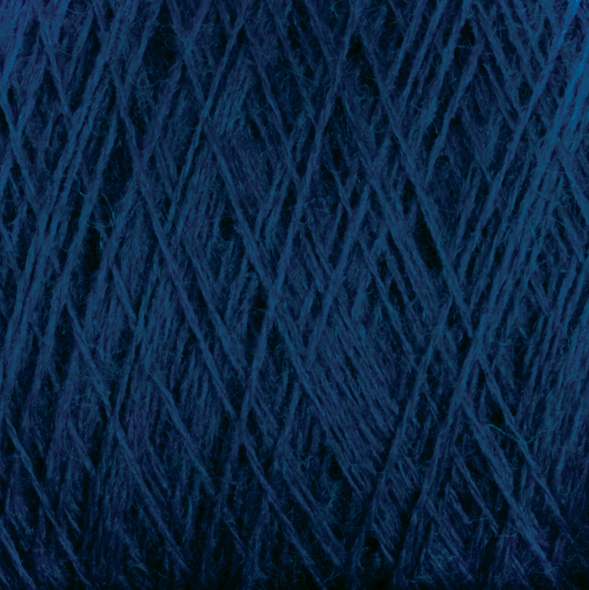 Close-up of JaggerSpun Maine Line 2/8 Yarn in dark blue from Jagger Brothers, Inc., showing tightly wound strands with intricate overlapping patterns and textures. The yarn has a slightly fuzzy appearance, ideal for knitting projects, enhancing its dense, rich hue.