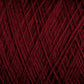 Close-up shot of JaggerSpun Maine Line 2/8 Yarn | Mini-cone from Jagger Brothers, Inc., wound into a dense, intricate ball. The texture is clearly visible, showcasing its fibrous nature and overlapping strands, perfect for weaving or knitting. The deep red color is rich and consistent throughout.