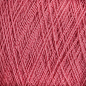 Close-up of light, pink JaggerSpun Maine Line 2/8 Yarn strands intricately wound and layered, forming a dense, crisscrossing pattern. The texture appears soft and fluffy, making it suitable for knitting or crochet projects. Bright lighting highlights the yarn's details and its vibrant color from Jagger Brothers, Inc.'s Mini-cone collection.