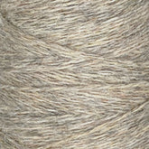 Close-up image of JaggerSpun Heather 2/8 | Mini-cone yarns from Jagger Brothers, Inc., wound tightly into a cylindrical shape. The texture appears slightly coarse, with fibers of varying shades of beige and light brown interwoven together, highlighting the beauty of worsted spun wool processed with low-impact synthetic dyes.