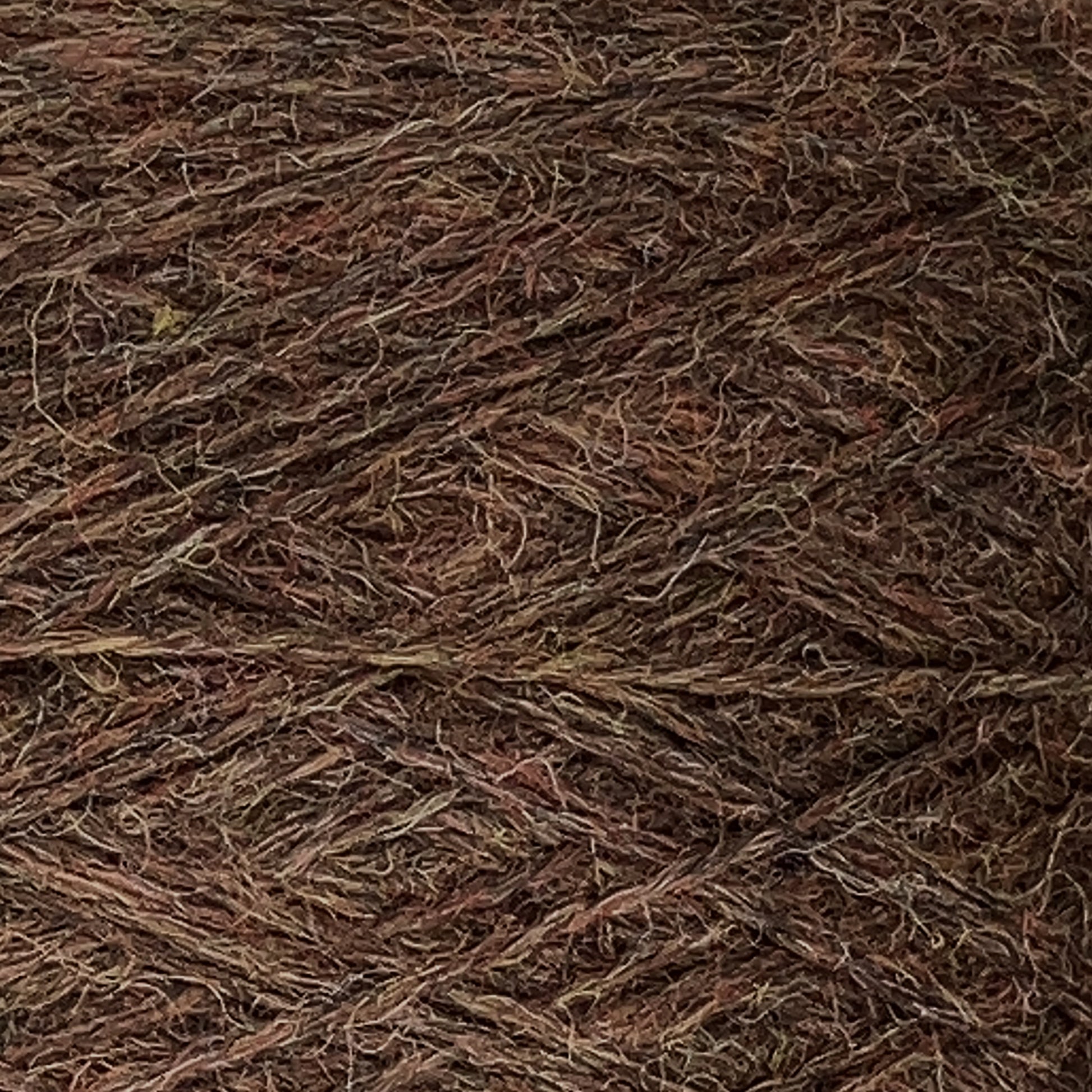 Close-up image of a textured, multicolored JaggerSpun Heather 2/8 yarn from Jagger Brothers, Inc. The worsted spun fibers feature interwoven hues of brown, green, and reddish tones, creating a rustic and earthy appearance. The tightly spun yarn showcases the intricate pattern and texture of the material on a large cone.