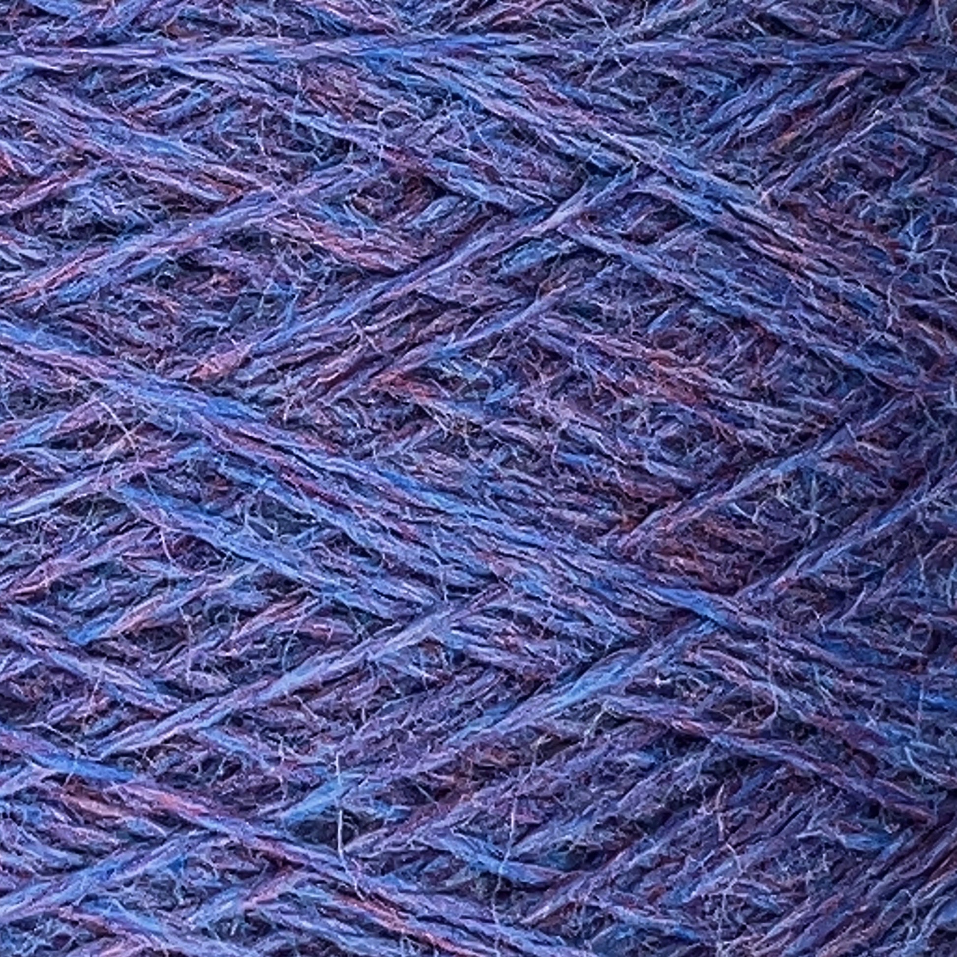 Close-up image of blue and purple Jagger Brothers, Inc. JaggerSpun Heather 2/8 mini-cone yarns wound in a crisscross pattern on a spool. The texture of the fibers and the interwoven threads are clearly visible, highlighting the intricate details of the worsted spun wool's composition.