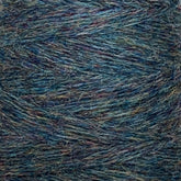 Close-up view of Jagger Brothers, Inc.'s JaggerSpun Heather 2/8 Mini-cone yarns in shades of blue, green, and hints of purple. The worsted spun wool's intertwining fibers, dyed with low-impact synthetic dyes, create a rich, multi-tonal appearance.