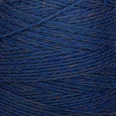 Close-up image of a spool of blue yarn reveals the intricate texture and individual strands wrapped around the spool. The yarn appears slightly fuzzy, showcasing a mix of darker and lighter blue fibers. Crafted from JaggerSpun Heather 2/8 Mini-cone by Jagger Brothers, Inc., it highlights fine detail and artisanal quality.