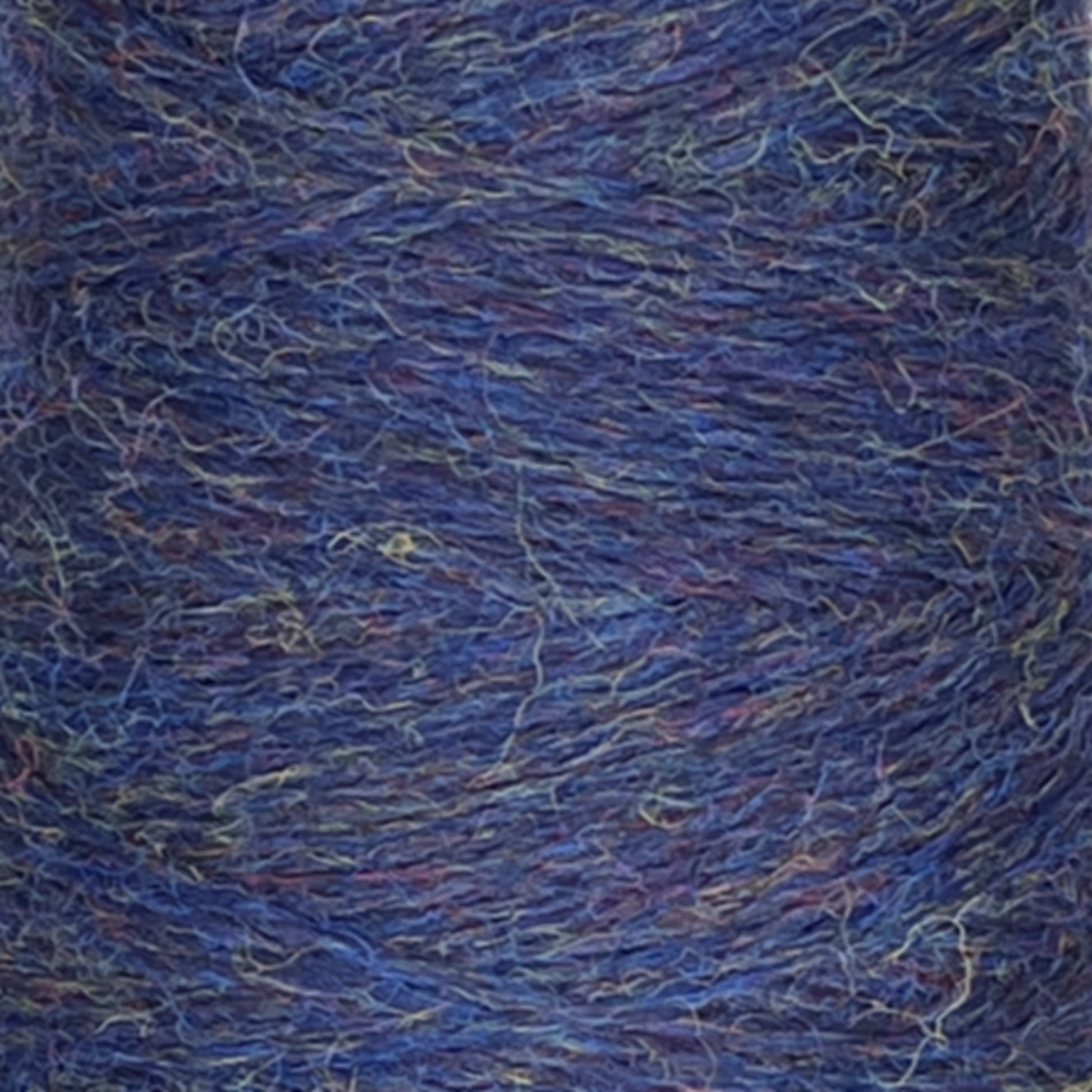 Close-up image of a spool of Jagger Brothers, Inc. JaggerSpun Heather 2/8 Mini-cone yarns showcasing a textured blend of blue, purple, and subtle green fibers. The intertwined strands create a thick, fuzzy appearance, suggesting its suitability for knitting or crochet projects.