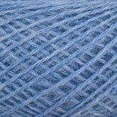 Close-up image of JaggerSpun Heather 2/8 Mini-cone yarns in blue. Made by Jagger Brothers, Inc. using low-impact synthetic dyes, this yarn has a soft, fuzzy texture and is coiled in a crisscross pattern that highlights the intertwined fibers. The shade of blue is light and uniform throughout the yarn.