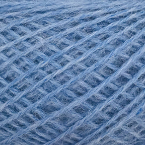 Close-up image of JaggerSpun Heather 2/8 Mini-cone yarns in blue. Made by Jagger Brothers, Inc. using low-impact synthetic dyes, this yarn has a soft, fuzzy texture and is coiled in a crisscross pattern that highlights the intertwined fibers. The shade of blue is light and uniform throughout the yarn.