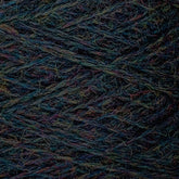 Close-up image of multicolored JaggerSpun Heather 2/8 yarns by Jagger Brothers, Inc. The strands of worsted spun wool are tightly wound together, showcasing a variety of colors including blue, green, and hints of red and yellow. The texture appears soft and slightly fuzzy.