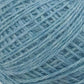 A close-up image of JaggerSpun Heather 2/8 yarns from Jagger Brothers, Inc., intricately wound into a mini-cone. The strands of yarn are clearly visible, showcasing the fibrous texture and slight variations in the blue color, ranging from pale blue to a slightly darker shade.