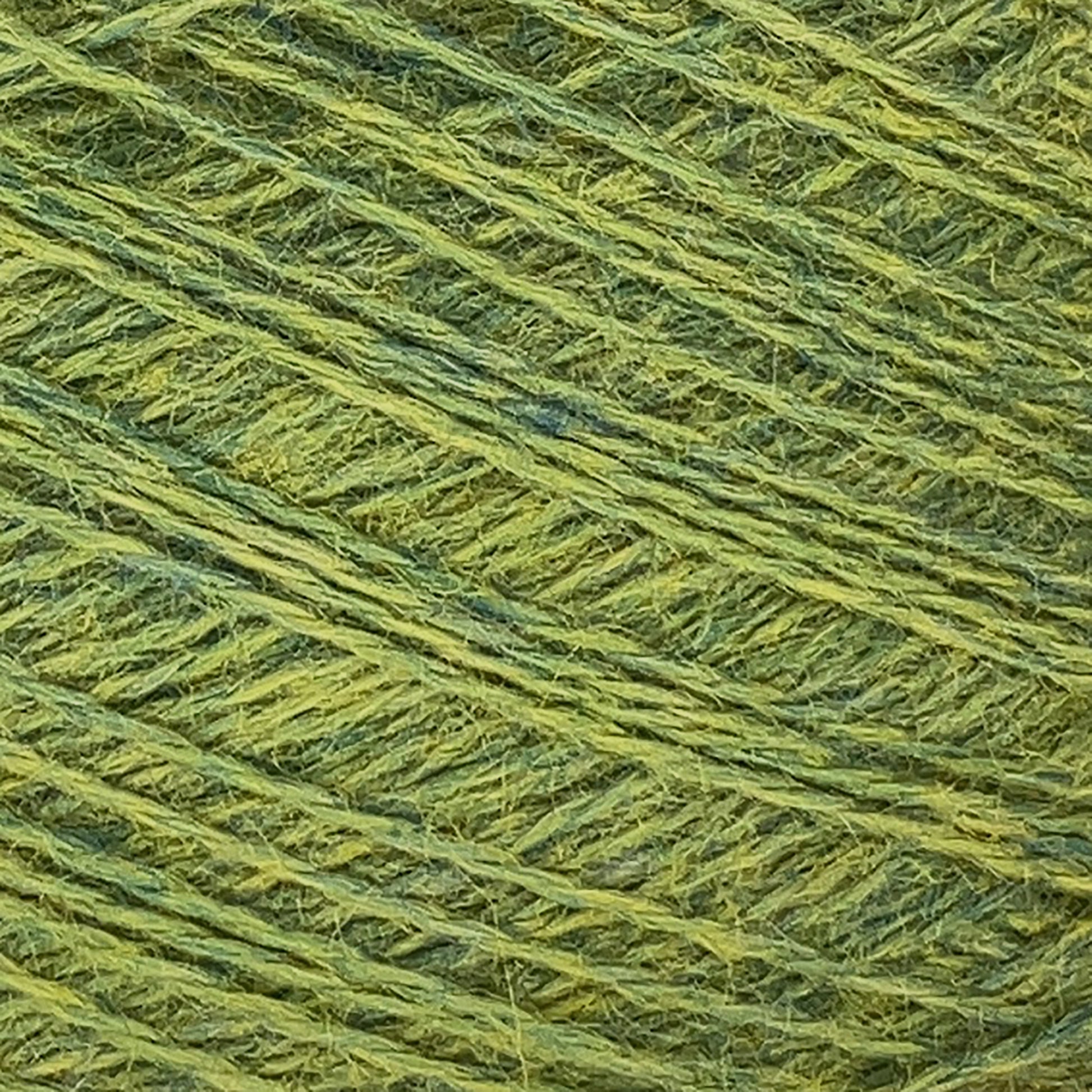 Close-up image of JaggerSpun Heather 2/8 Mini-cone yarns by Jagger Brothers, Inc., showcasing the detailed texture and interwoven fibers. This worsted spun wool, dyed with low-impact synthetic dyes, features shades of green ranging from light to medium, with visible strands intertwined in a consistent pattern.